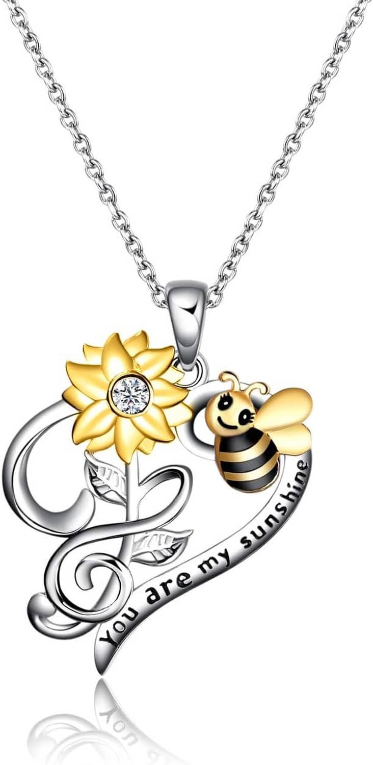 Bee, gold flower, and silver heart pendant on a linked chain