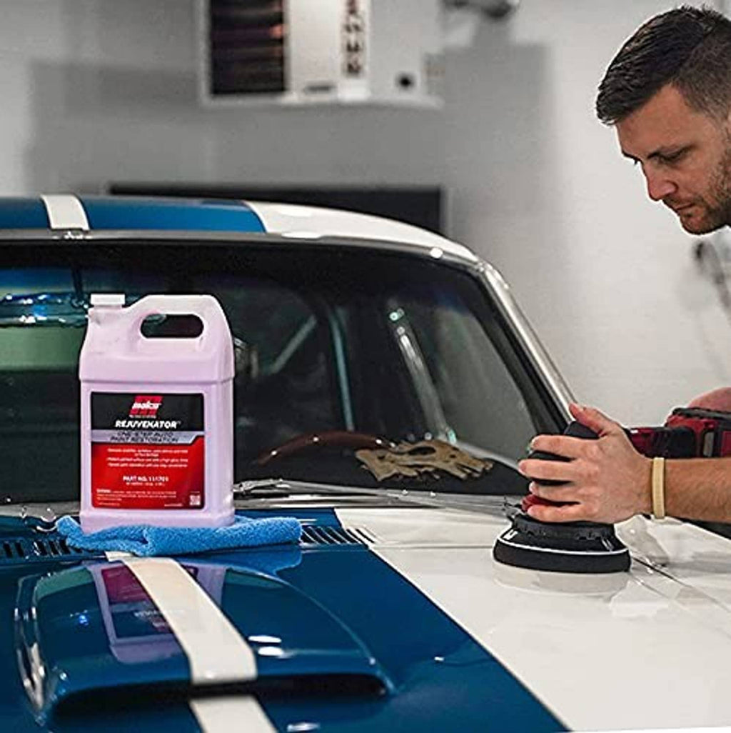 Auto paint restoration bottle with blue cloth and polishing pad on car hood