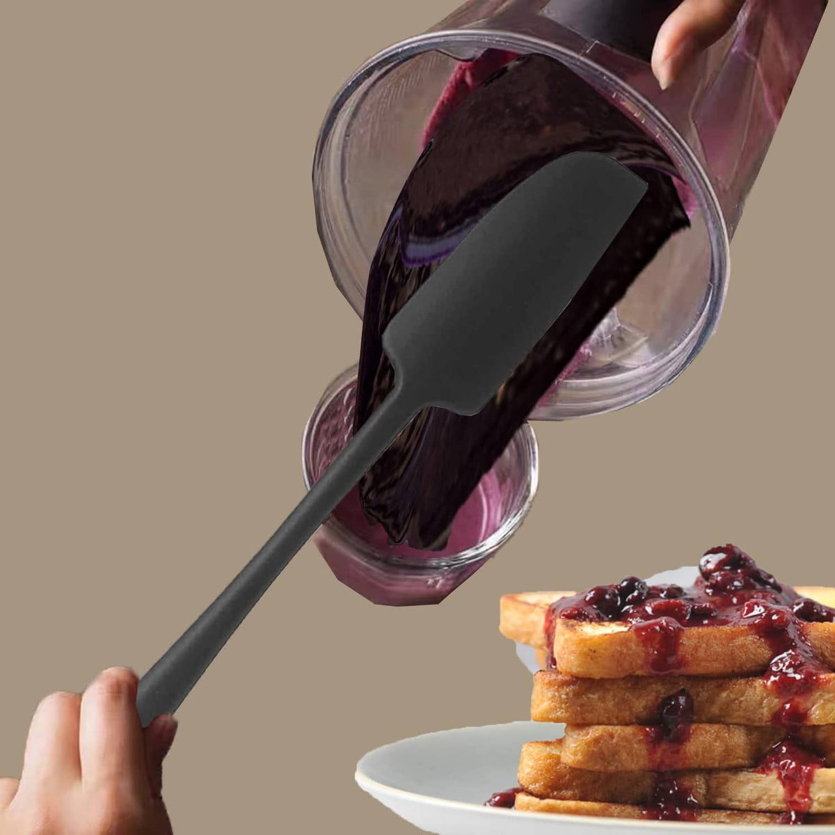 Black silicone spatula lifting dark spread from a container