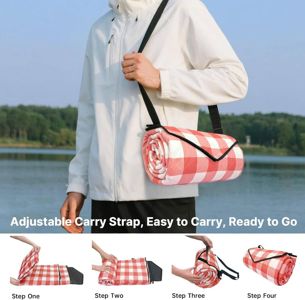 Red-and-white check picnic blanket rolled with adjustable shoulder carry strap