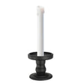 Matte black glass candle holder with flared base, holding a taper candle