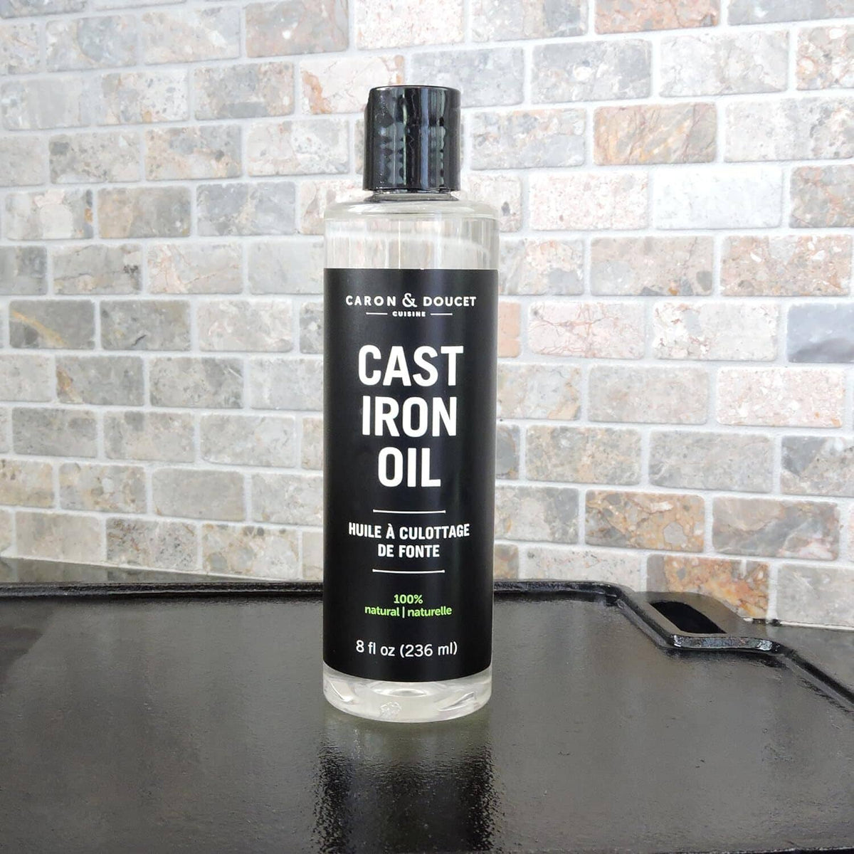 Caron & Doucet Cast Iron Oil bottle, black cap, front label with 100% natural.