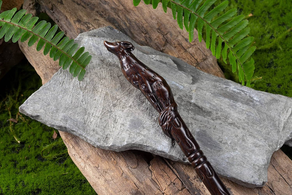 Dark brown carved wooden witch wand with ornate raised patterns and pointed tip