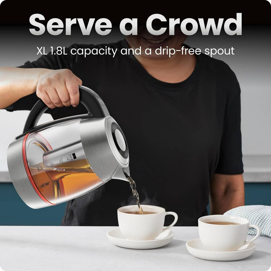 Stainless steel electric kettle pouring hot water from the spout into a cup.