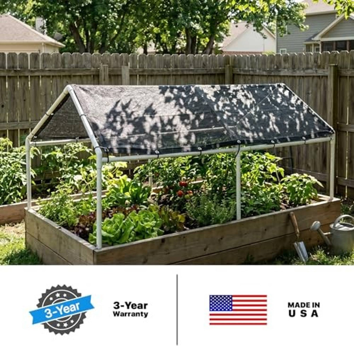 Black shade cloth roof over a backyard greenhouse covering raised garden beds