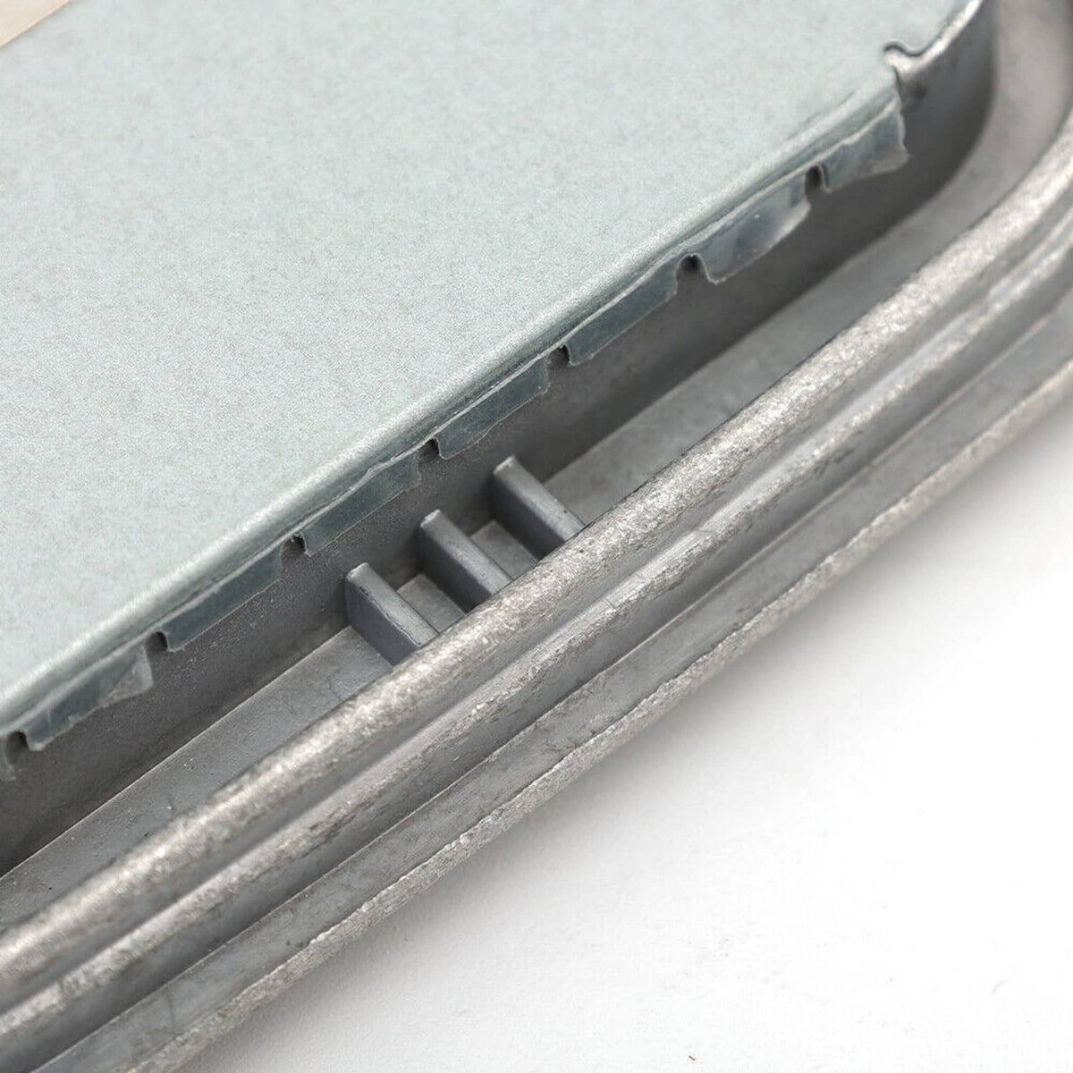 Xenon HID headlight ballast module metal cover with vented strip detail