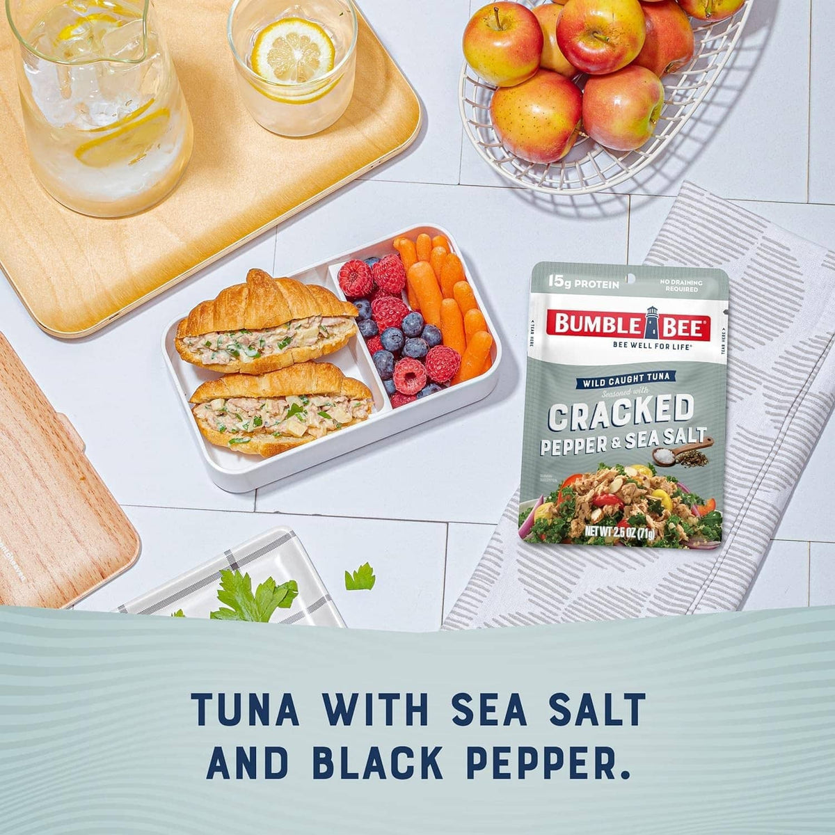 Cracked pepper & sea salt tuna pouch with prepared meal and fruit on table