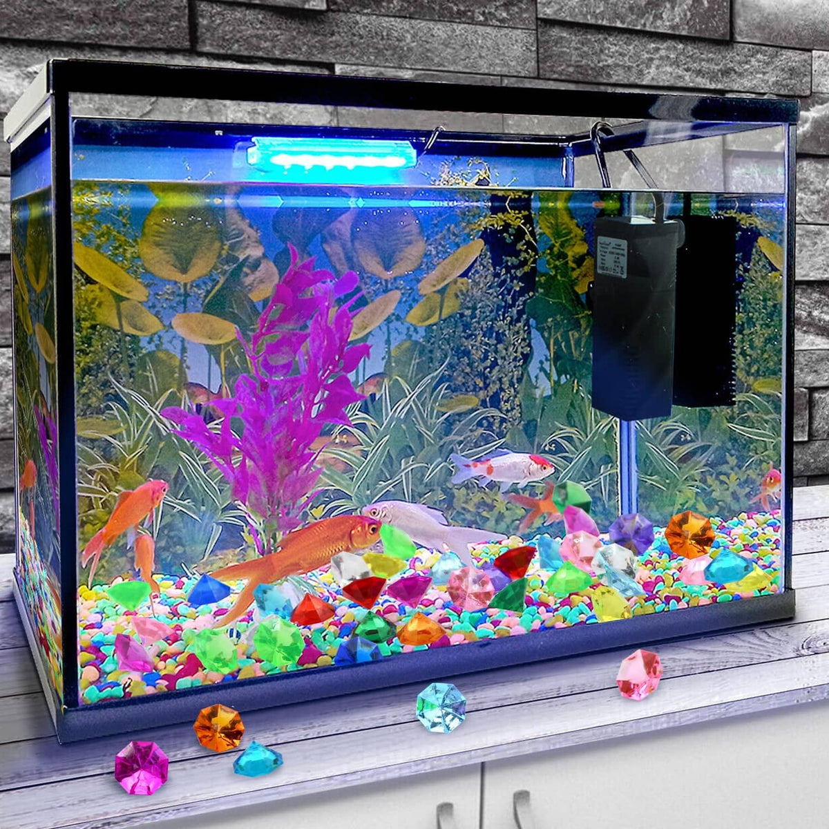 Multicolor faceted acrylic diamond gems displayed in an aquarium-style tank