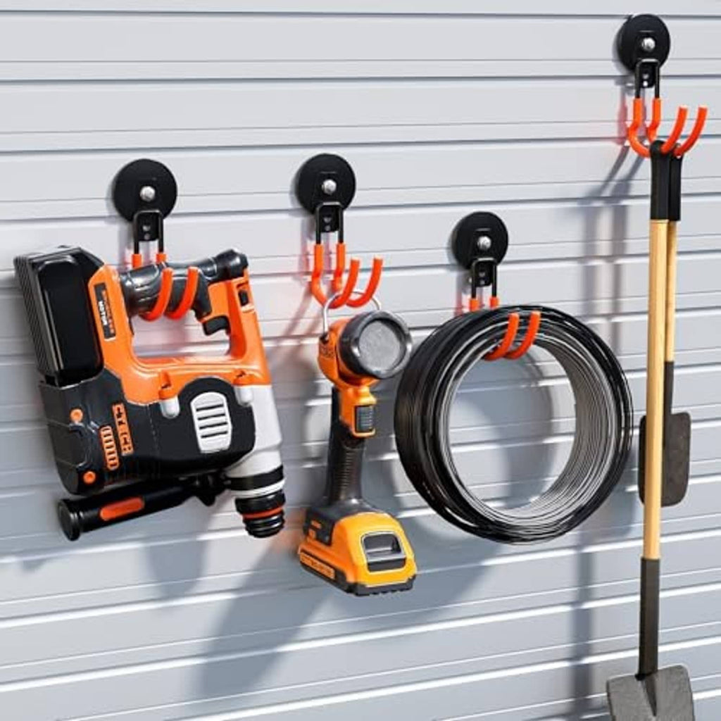 Magnetic garage hooks with black bases and orange curved arms mounted on a wall
