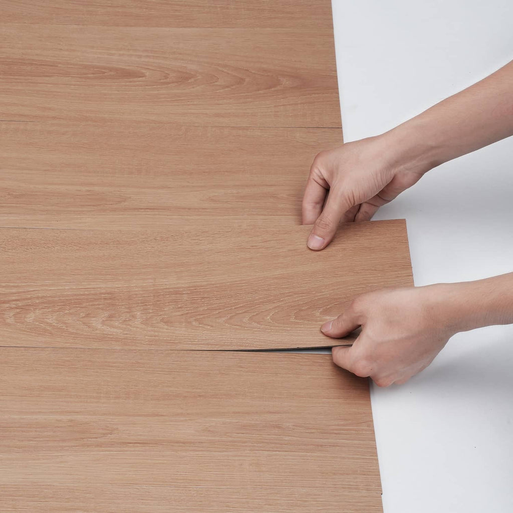 Natural wood-grain self-adhesive PVC floor tile panel with hands pressing edges