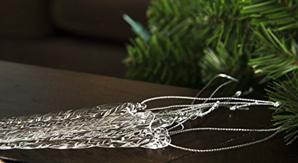 Close-up of a clear glass icicle ornament with twisted ridges and silver-tone loop