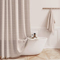 Taupe boho shower curtain with subtle grid pattern and tassel trim