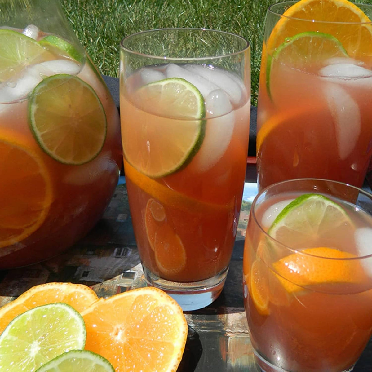 Clear 20 oz beverage glasses with orange drink, ice, and citrus slices
