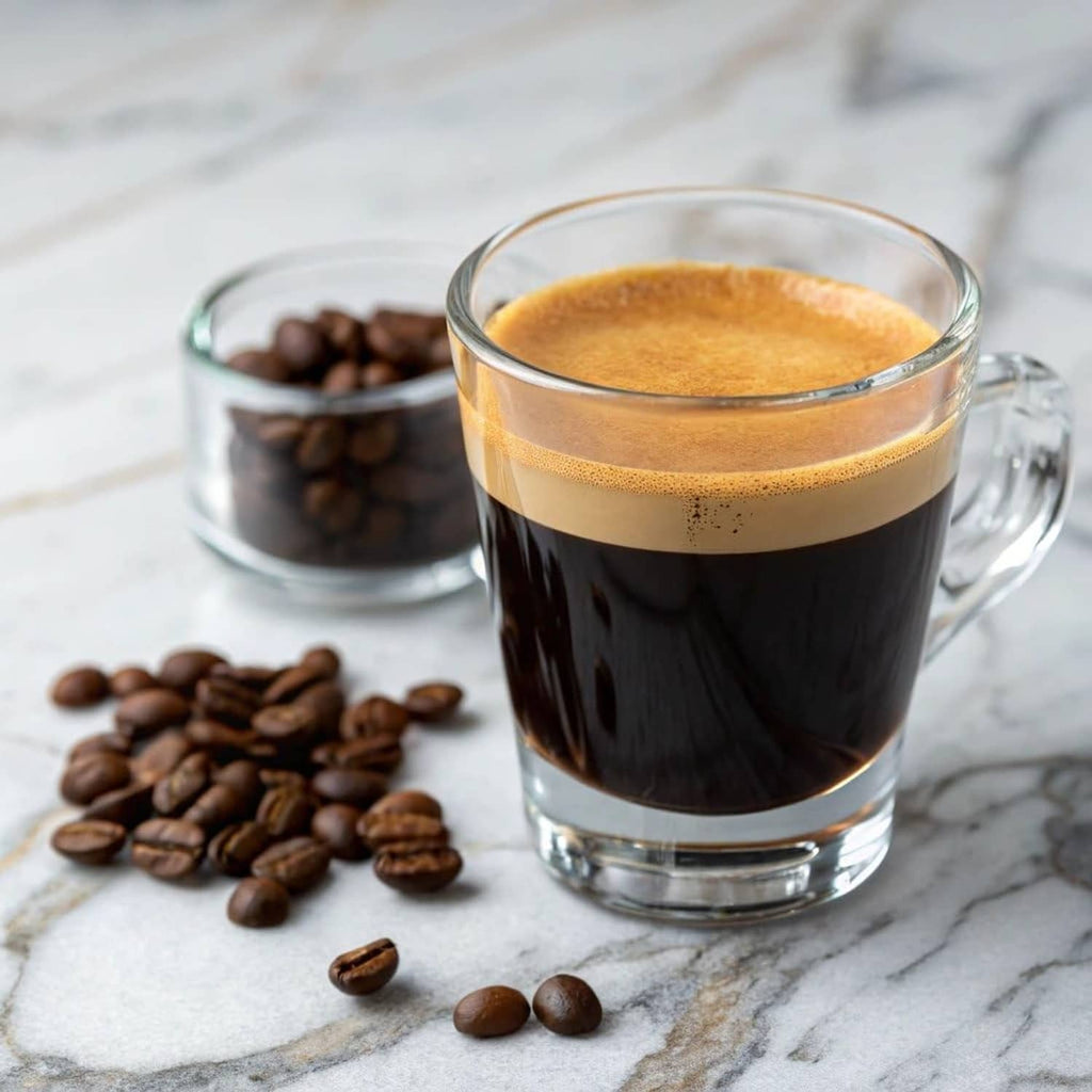 Glass cup of dark coffee with crema and whole coffee beans beside it