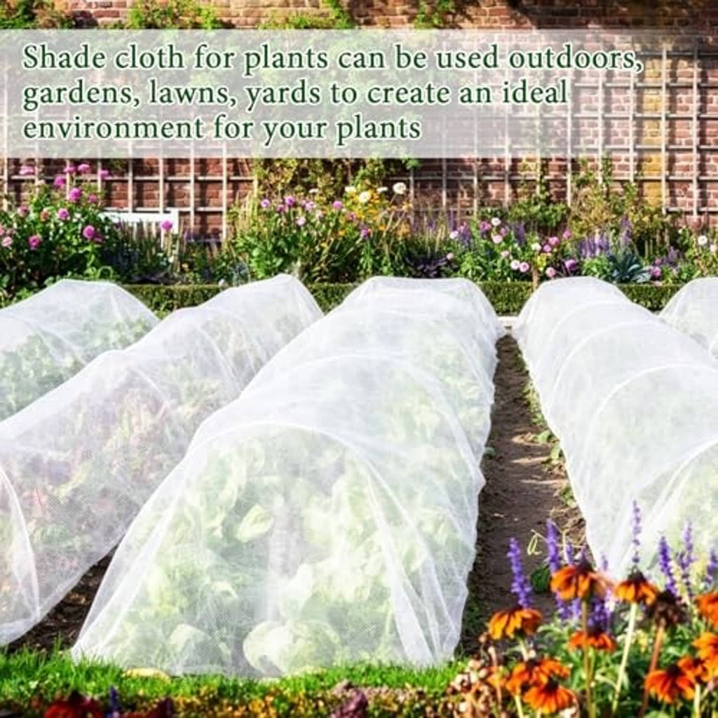 Multiple white shade cloth covers over garden rows, forming rounded protective tunnels.