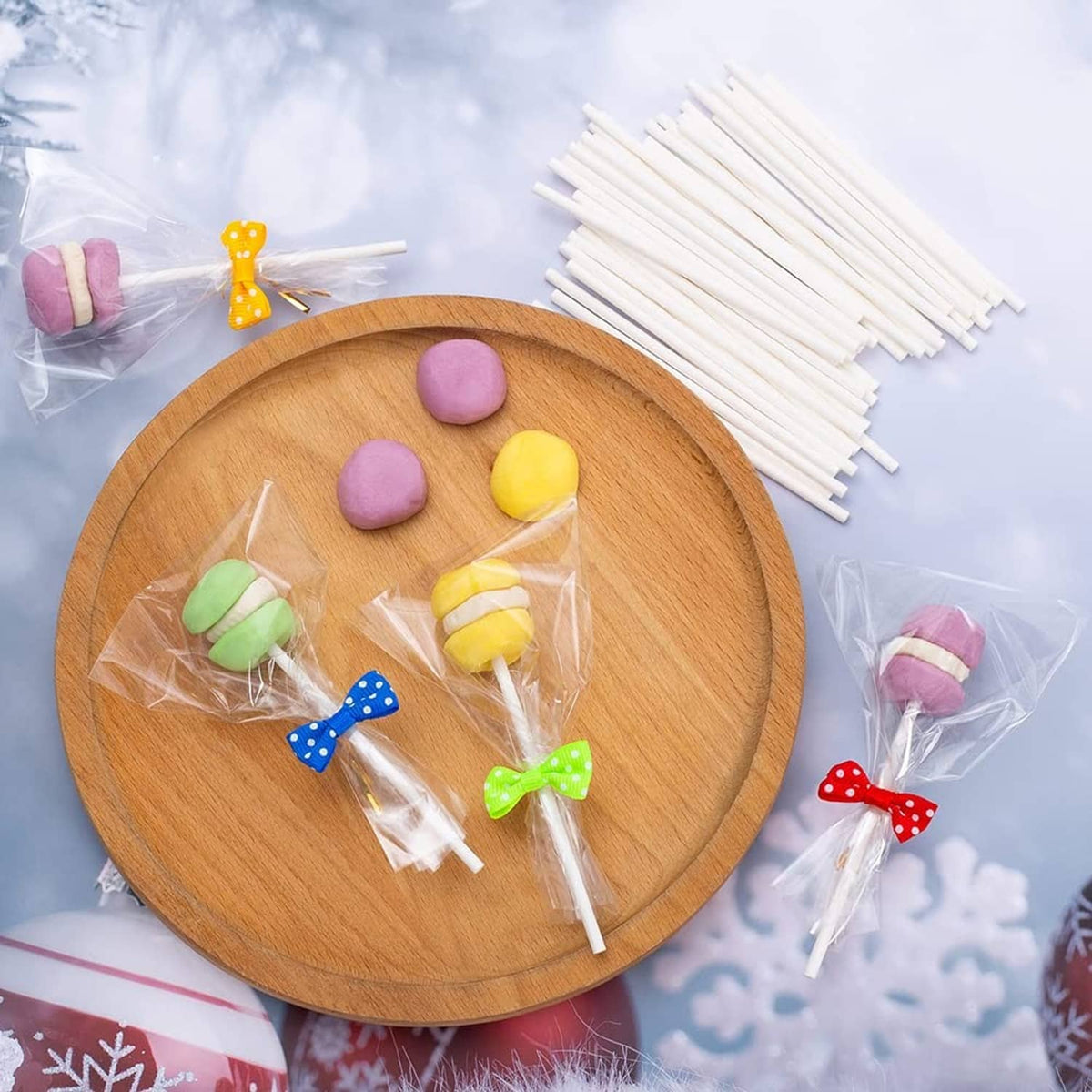 Set of white cake pop sticks with clear wrapper bags and assorted candy topper stickers