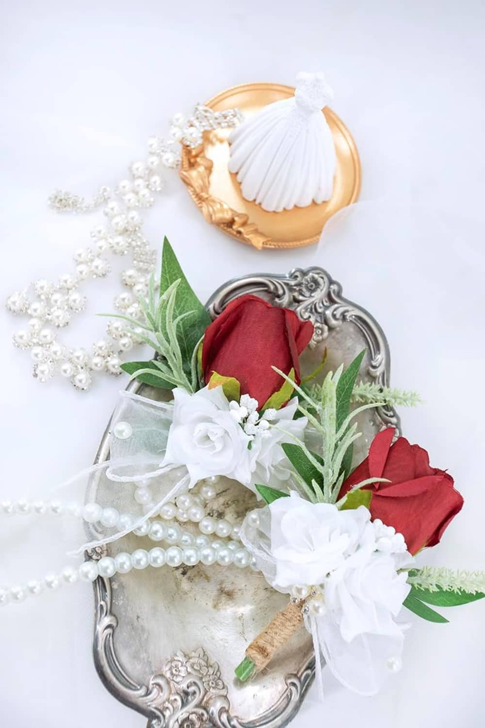 Artificial corsage and boutonniere with burgundy rose, white ruffles, pearls, green foliage, gold accents