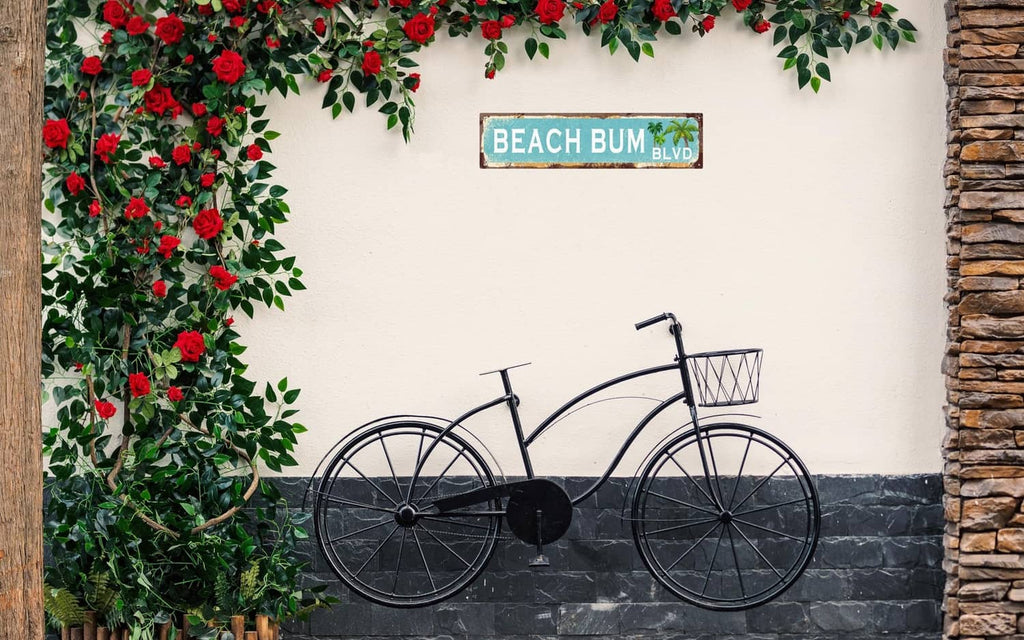 Vintage tin wall sign reading “BEACH BUM BLVD” with palm tree graphic