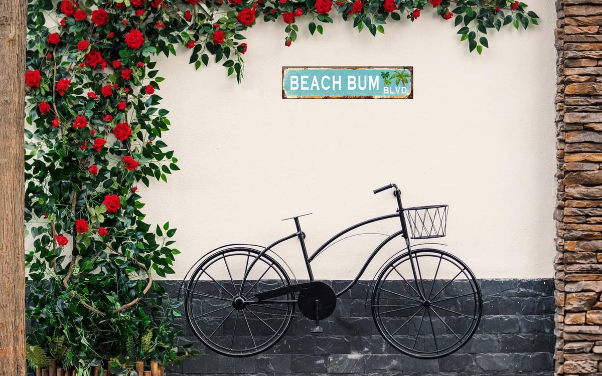 Vintage tin wall sign reading “BEACH BUM BLVD” with palm tree graphic