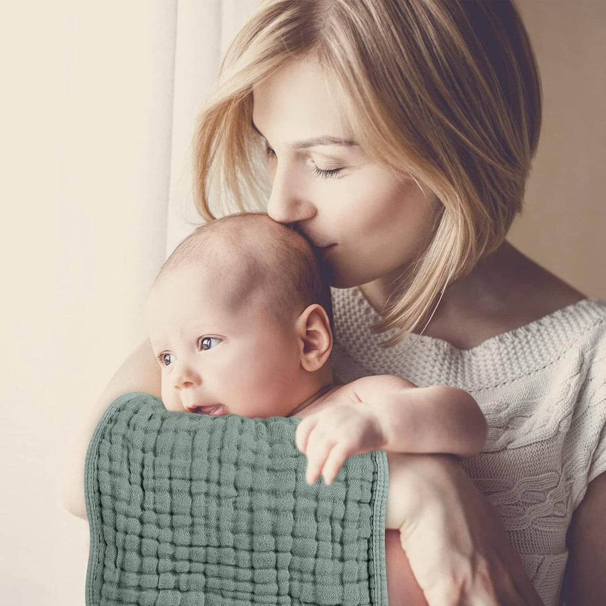 Muslin burp cloth in sage green, draped over baby’s shoulder during feeding or burping
