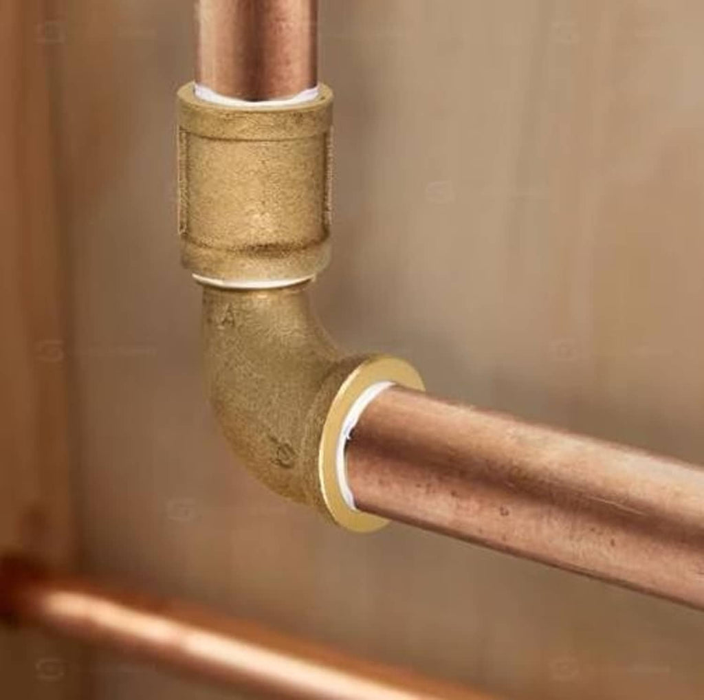 Installed brass 90-degree street elbow connecting copper pipes with threaded joint
