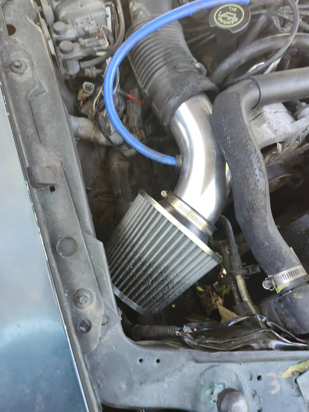 Cold air intake filter kit installation detail: black cone filter and blue silicone hose