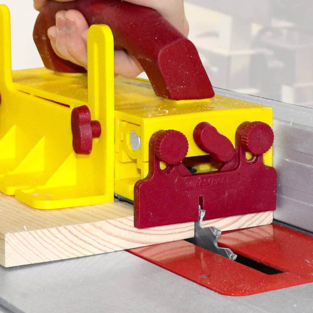 Yellow push block with maroon finger guard and red anti-kickback pads on wood