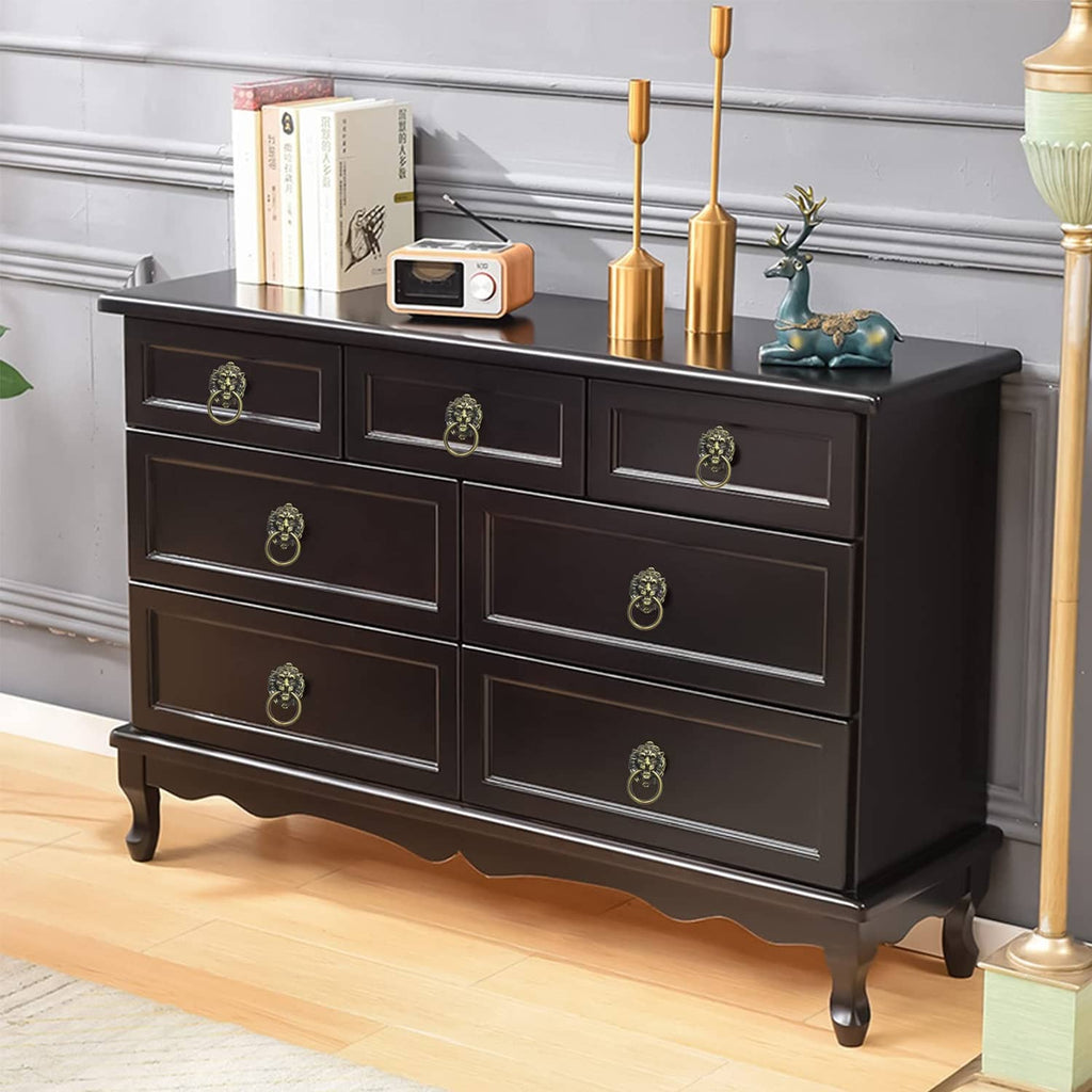 Lion head drawer pull handles on dark dresser drawers with bronze ring accents
