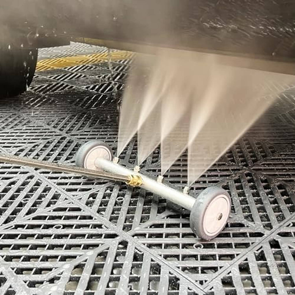 Underbody pressure washer attachment spraying water onto metal grate from a wheeled wand