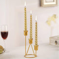 Gold three-cup candle holder with twisted candlesticks on a round stand