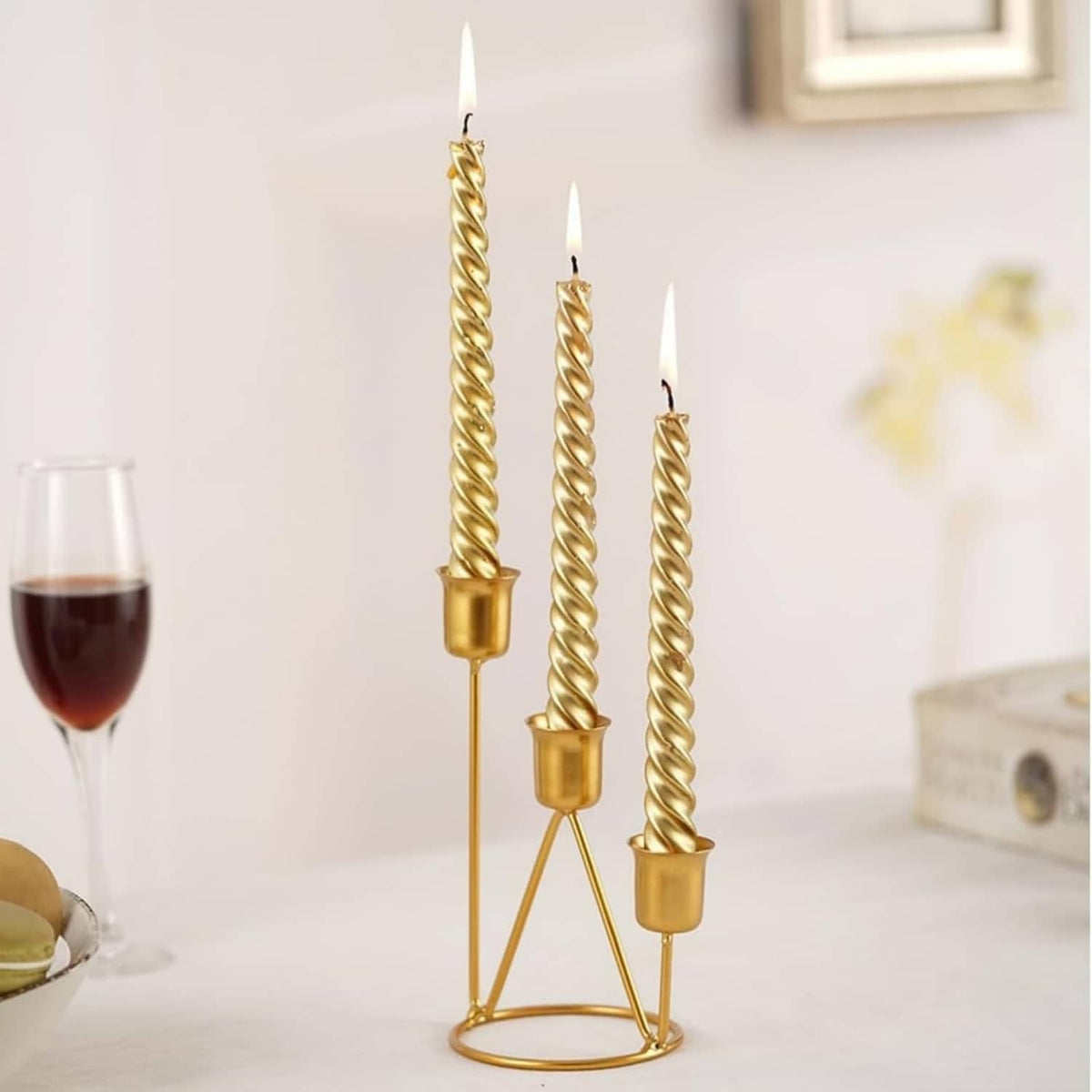 Gold three-cup candle holder with twisted candlesticks on a round stand