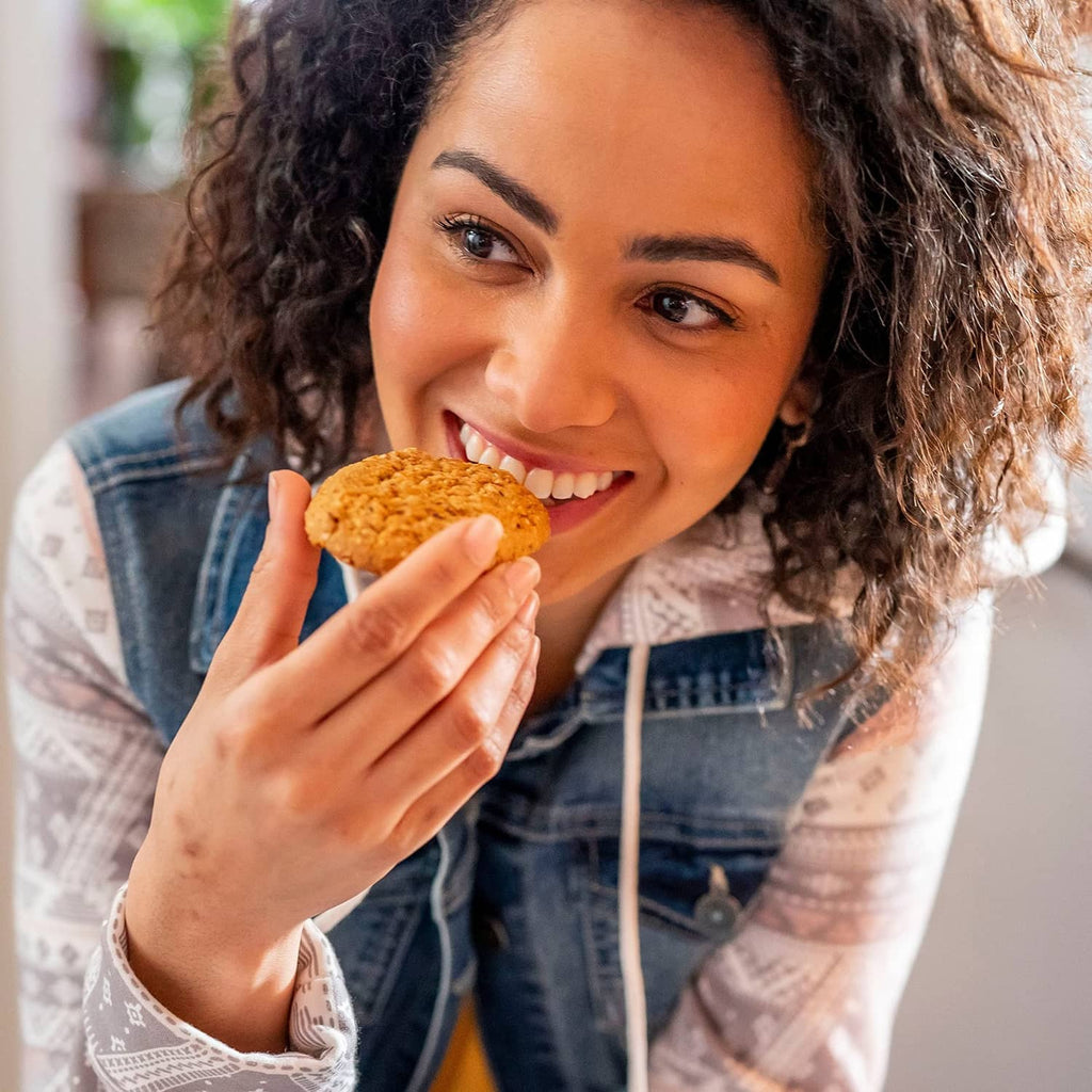 Person smiling and holding a soft baked banana bread breakfast biscuit