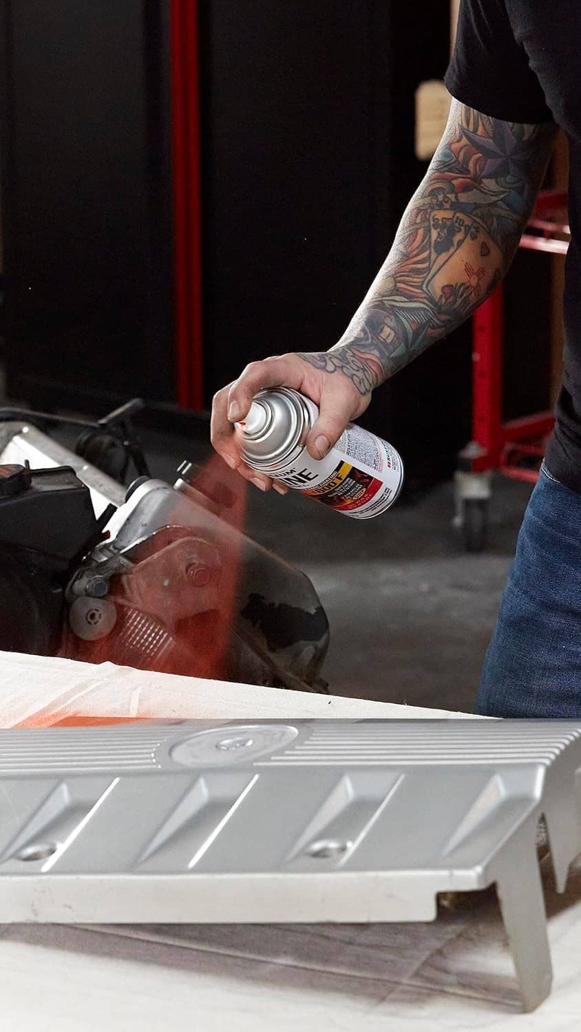 Spray paint application on engine valve cover; can releasing mist on metal surface