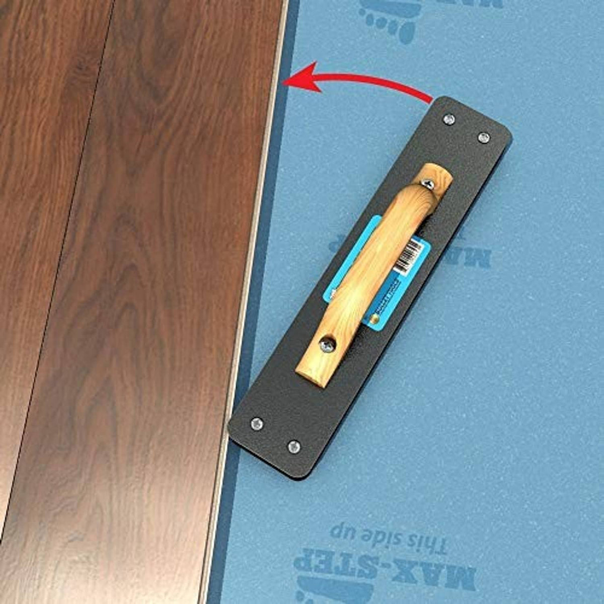 Flooring tapping block tool shown against flooring edge, black plate with wood striker