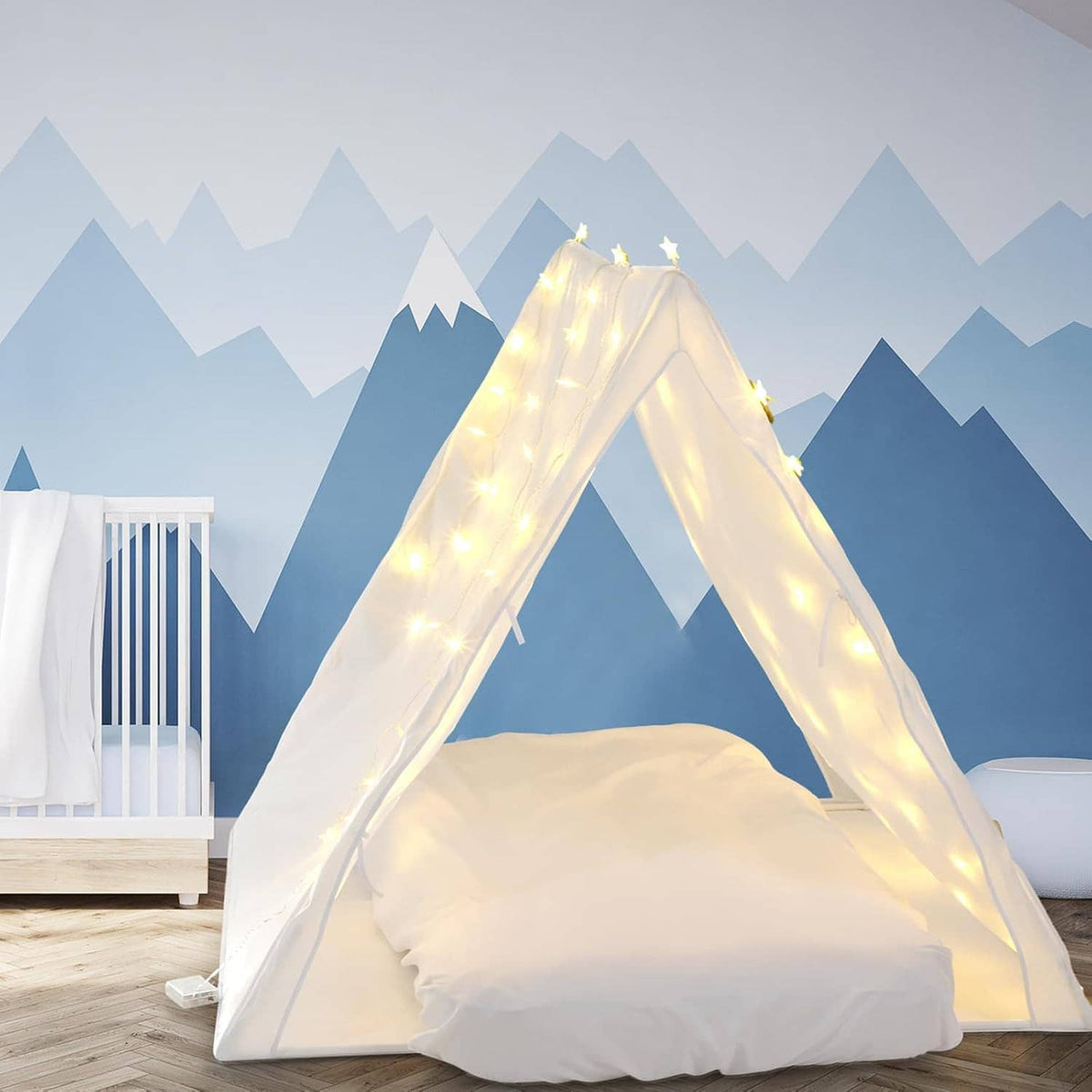 White teepee sleepover tent with warm fairy lights and inflatable airbed on floor