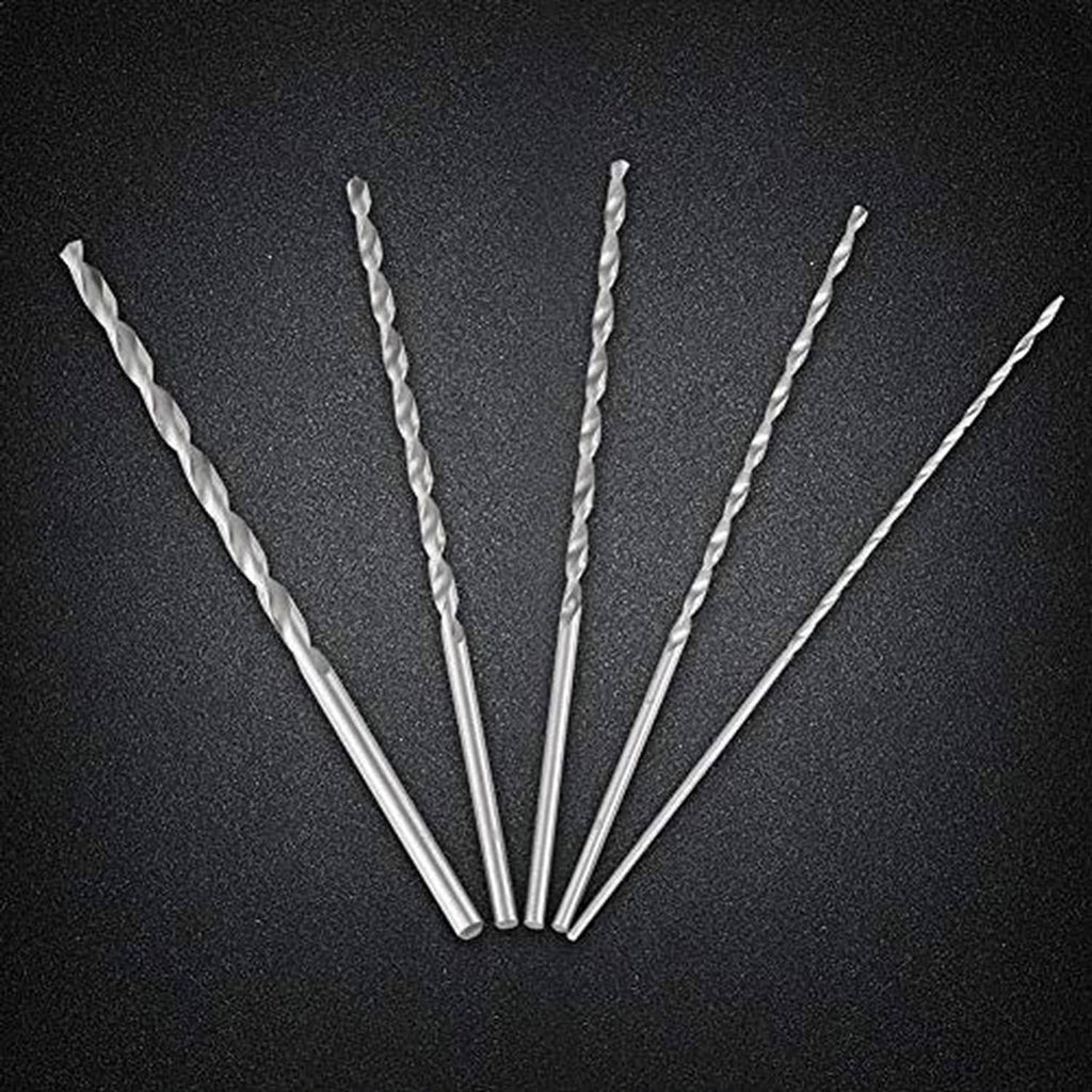 Five silver spiral twist drill bits fanned out on a dark surface