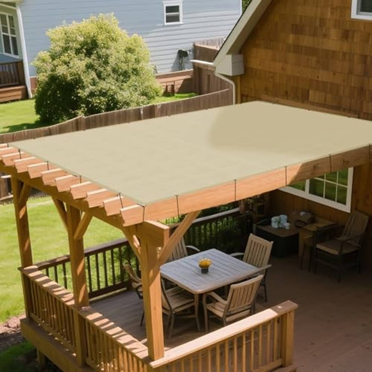 Beige rectangular shade sail over outdoor dining area on wooden pergola
