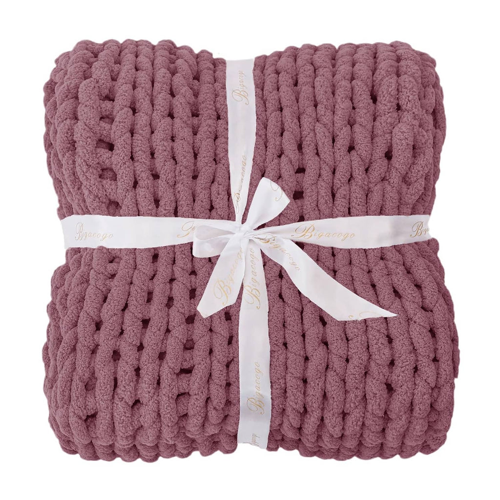 Folded chunky knit throw blanket, burnt rose, tied with white ribbon