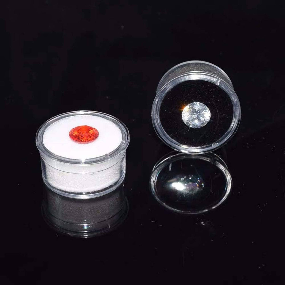 Clear round gemstone display boxes with red and light gem stones in foam