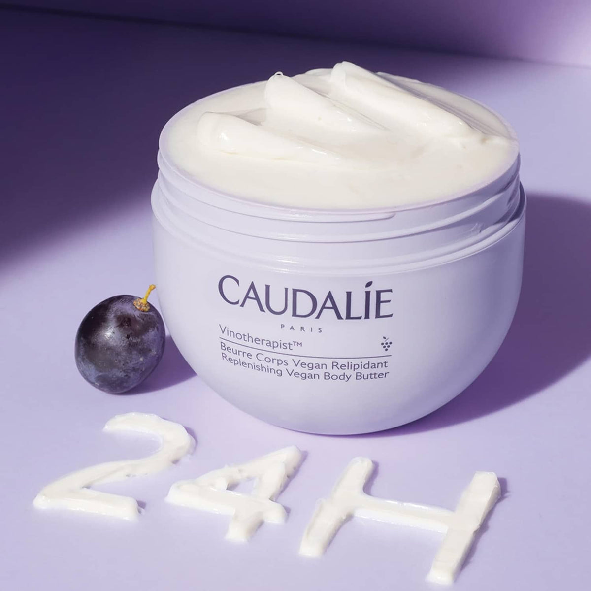 CAUDALIE body butter jar with thick white cream and small grape accents