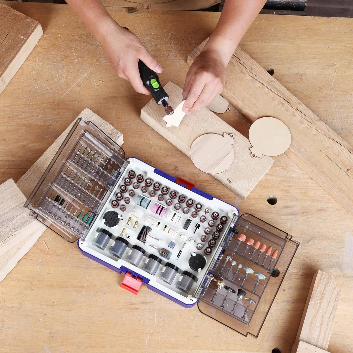 Open rotary tool accessory kit with neatly arranged bits on a workbench surface