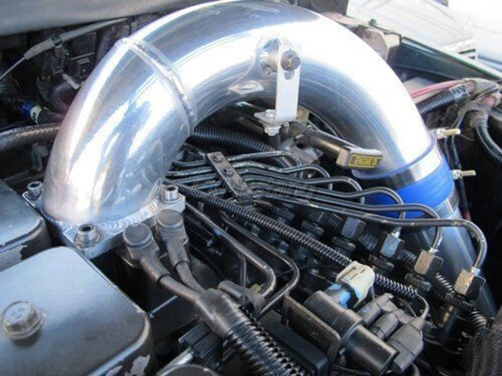 Stainless intake elbow with blue silicone coupler, mounted on engine