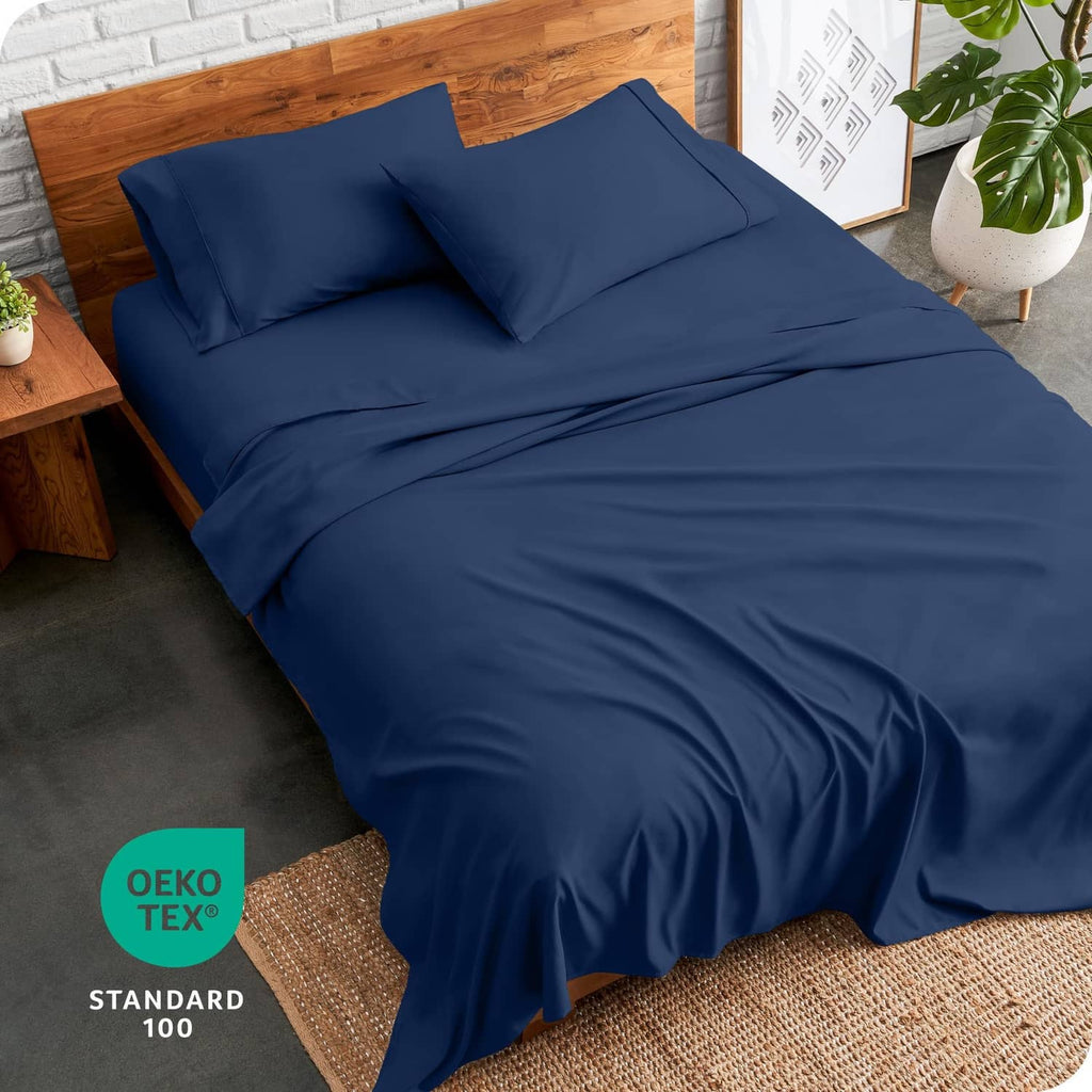Dark blue full bed sheet set with fitted sheet and pillowcases on a bed surface