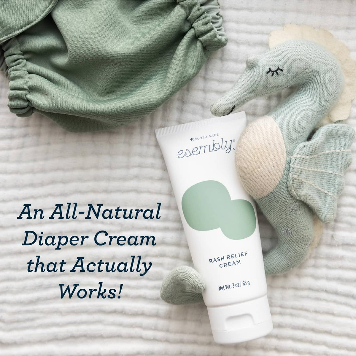Esembly rash relief cream tube with green logo beside cloth diapers and socks