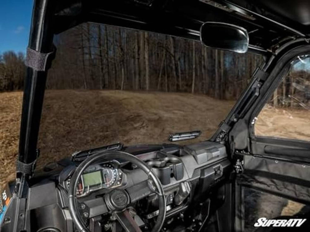 Interior view through dark-tinted windshield with dashboard visible from driver seat