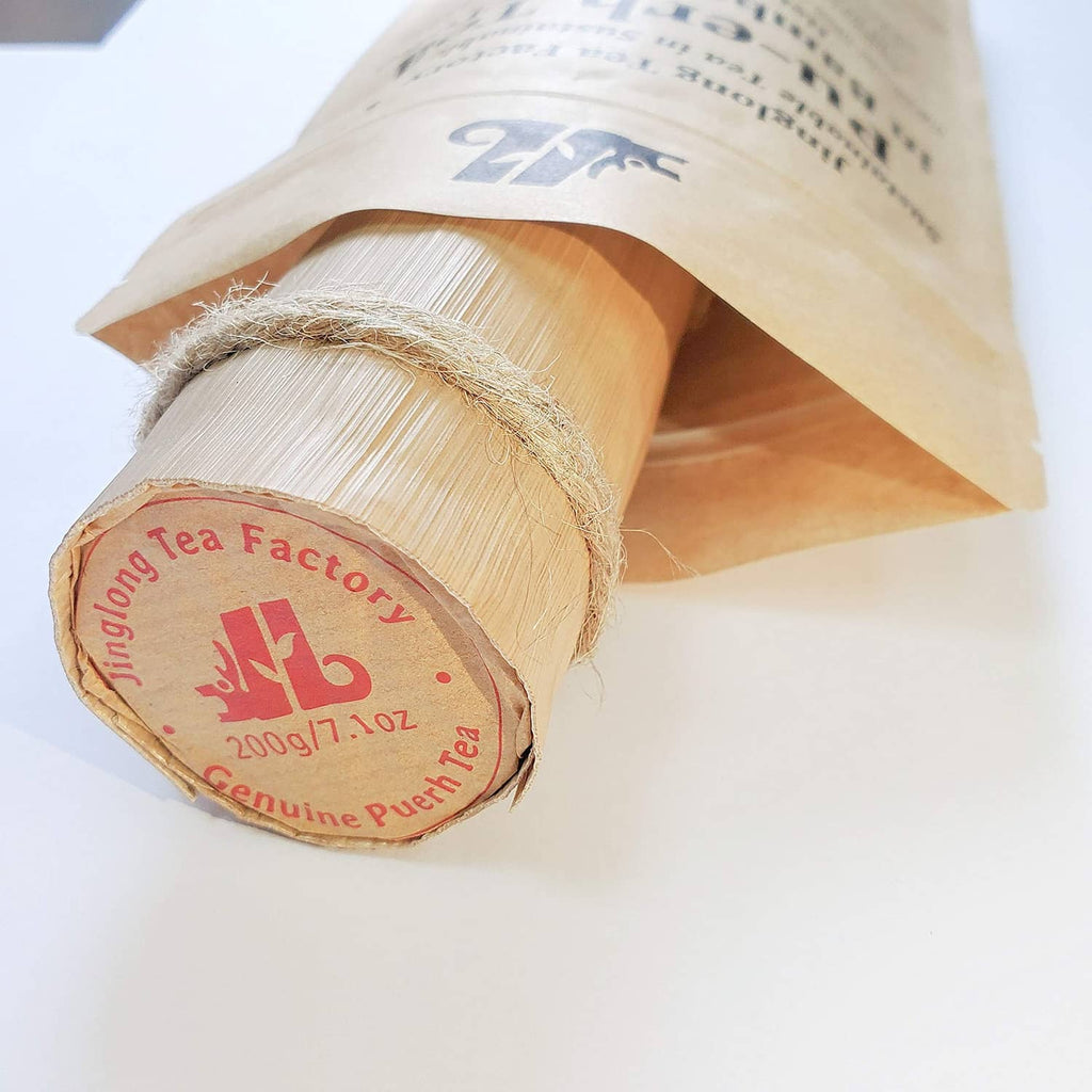 Pu-erh tea bamboo leaf tube end with round label and visible wrapping fibers