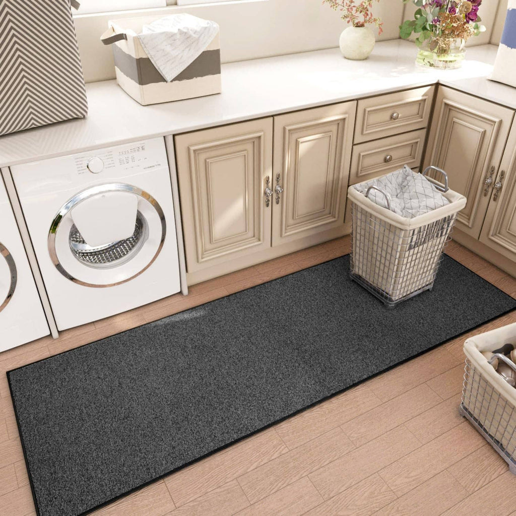 Charcoal gray runner rug in kitchen area with low pile texture and black border