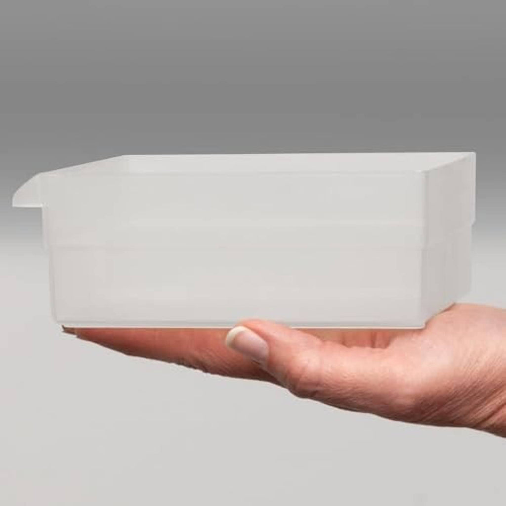 Hand holding a white plastic drawer insert or bin, side view
