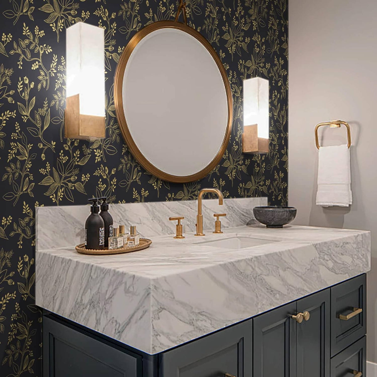 Black and gold botanical wallpaper on bathroom wall behind vanity mirror and sink