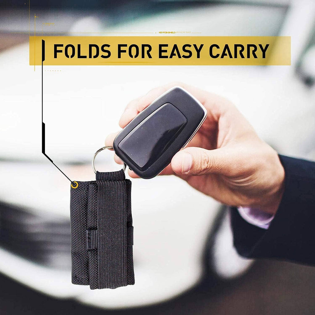 Black Faraday key fob bag with belt-style holder, held with key fob